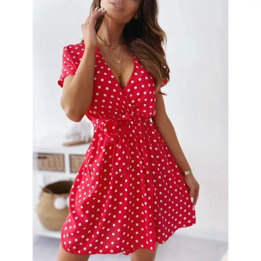 Woman wearing a red polka dot dress in a minimal indoor setting