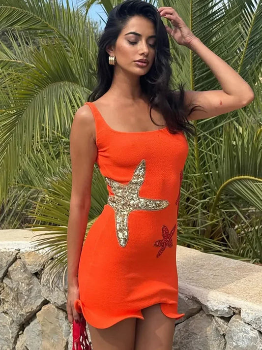 Woman wearing an orange dress with a starfish design in a tropical setting