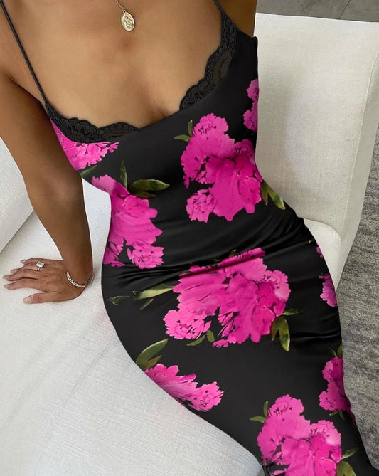 Black dress with pink floral pattern worn by a person sitting on a white couch.
